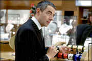Salesman (Rowan Atkinson) beginning to wrap the necklace